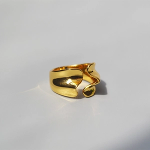 Close-up of minimalist irregular 18K gold plated silver open ring with wavy texture