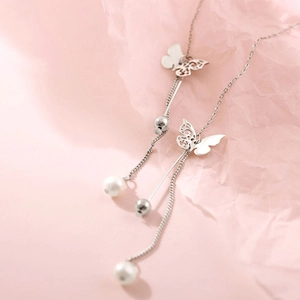 Detailed close-up of butterfly tassel earrings with silver finish and lustrous white pearls