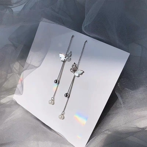 Silver butterfly tassel earrings with long chains and pearls displayed on a card