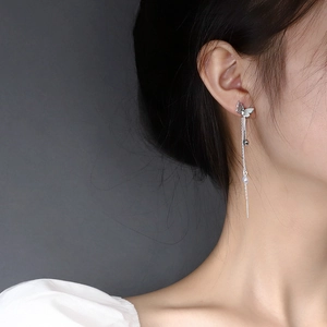 Elegant silver butterfly tassel earrings with long chain pearls shown on a female model