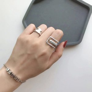 Polished silver lucky letter bracelet and geometric wide band ring set on model