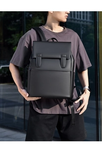 Man wearing a black waterproof business backpack in an urban city street setting