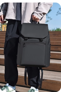 Close-up of black minimalist waterproof travel backpack with flap closure and hidden front pocket
