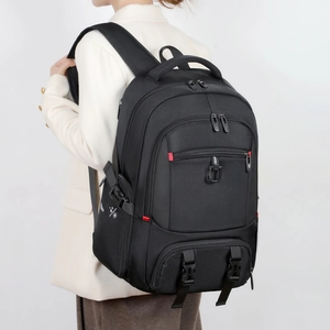 Side view of large black travel backpack with red zipper accents and buckle details