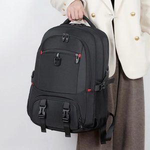 Detail of multi-compartment black travel backpack with buckle straps and side mesh pockets
