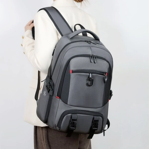 Side view of large gray travel backpack with padded straps and red zipper details