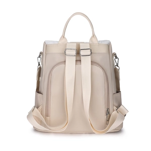 Detail of beige nylon backpack featuring adjustable straps and hidden anti-theft back pocket