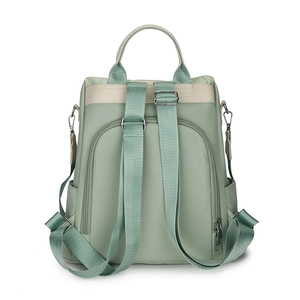 Back view of mint green nylon backpack showing anti-theft zipper pocket and straps