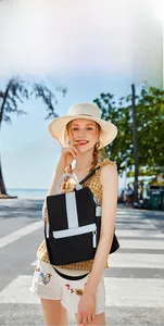 Outdoor shot of a black women's backpack with wavy stitching and H-shaped decor