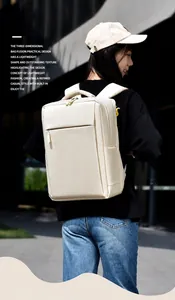 Side view of large beige leather backpack worn by a model against a modern building