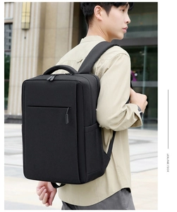 Water-resistant black business laptop backpack shown on model in urban street setting
