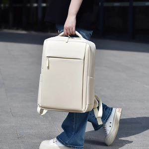 Close-up of minimalist cream backpack with padded mesh handle and hidden zipper pocket