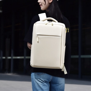 Side view of a cream minimalist business laptop backpack worn by a model in modern city