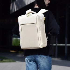 Close-up of minimalist beige business backpack with padded handle and premium matte texture