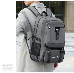 Detail view of large grey outdoor backpack showing multiple pockets and durable buckles