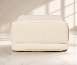 Detailed view of reinforced bottom stitching on an off-white canvas travel backpack