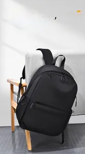 Détail du sac à dos business noir étanche posé sur un canapé montrant la poche latérale
