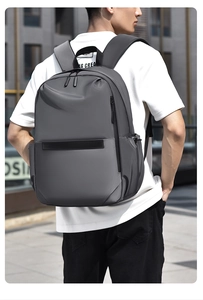 Photo extérieure d'un homme portant un grand sac à dos étanche gris foncé pour ordinateur