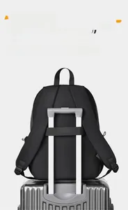 Détail de la sangle arrière du sac à dos fixée sur la poignée d'une valise argentée
