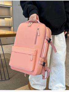 Detailed view of pink nylon backpack with side compression straps and thick top handle