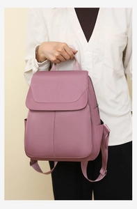 Detailed view of mauve anti-theft oxford backpack worn on back over a white shirt