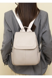 Rear view of a model wearing a beige Oxford fabric anti-theft backpack for daily commute