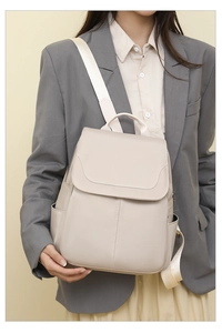 Detail of beige anti-theft oxford backpack with flap closure shown on a model