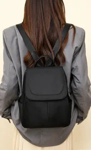 Detail of black anti-theft oxford backpack featuring flip cover and adjustable straps