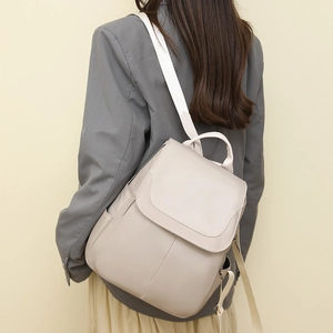 Detail view of beige anti-theft oxford backpack featuring adjustable fabric shoulder straps