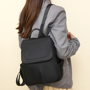 Detail of waterproof black oxford cloth backpack showing strap and matte fabric texture