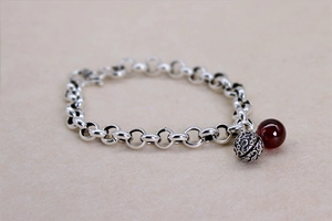 Detail eines Retro-Armbands aus Thai-Silber mit roter Achatperle und Glockenanhänger