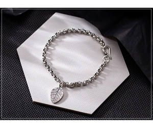 Detail of vintage S925 silver leaf charm bracelet with textured links and S-hook clasp