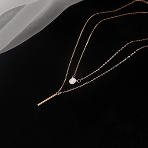 Detail view of double-layer rose gold sterling silver necklace with zircon and bar pendants