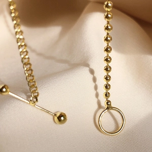 Detail of S925 silver beaded chain with OT toggle clasp on beige silk background