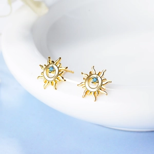 S925 silver sunflower stud earrings with blue zircon in a golden finish on a white tray