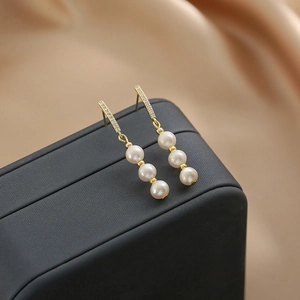 Elegant gold drop earrings featuring micro-set zircons and three dangling round pearls