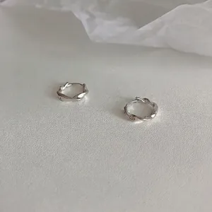 Detailed close-up of S925 sterling silver Mobius hoop earrings with twisted design