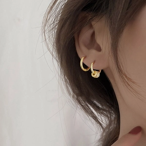 Detail of gold-plated 925 silver hoop earrings with micro-pave cubic zirconia charms