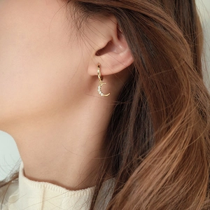 Close-up of S925 silver moon stud earrings with zircon stones on a model's ear
