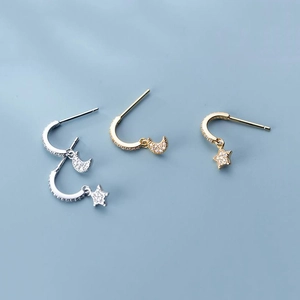 Close-up of S925 silver star and moon earrings with pavé crystals in gold and silver