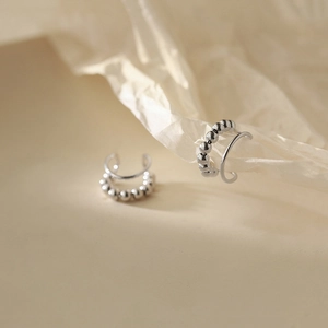 Dettaglio di earcuff in argento a doppio strato con anello liscio e trama di perline