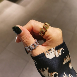 Close-up of Cuban chain link open rings in gold and silver finishes on a model hand