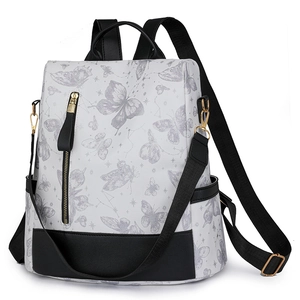Detail of white nylon backpack featuring gray butterfly patterns and black contrast trim
