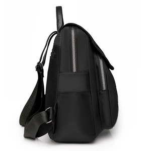 Side view of black water-resistant nylon backpack with silver zippers and leather handle
