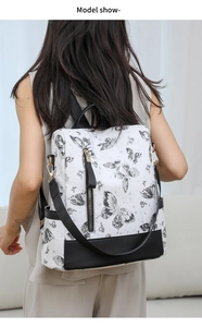 Detailed back view of nylon backpack featuring ink butterfly print and gold hardware
