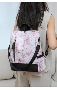 Detail of floral butterfly print on a nylon backpack with premium gold-tone metal hardware