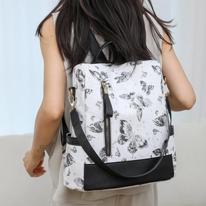 Fashionable white nylon backpack with butterfly print shown on a female model for size reference