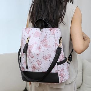 Close-up of embroidered butterfly and constellation pattern on black nylon backpack