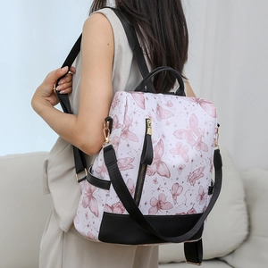 Detail of white nylon backpack with pink butterfly print and black leather accents