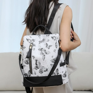 Detail of white nylon backpack with butterfly print and black faux leather accents